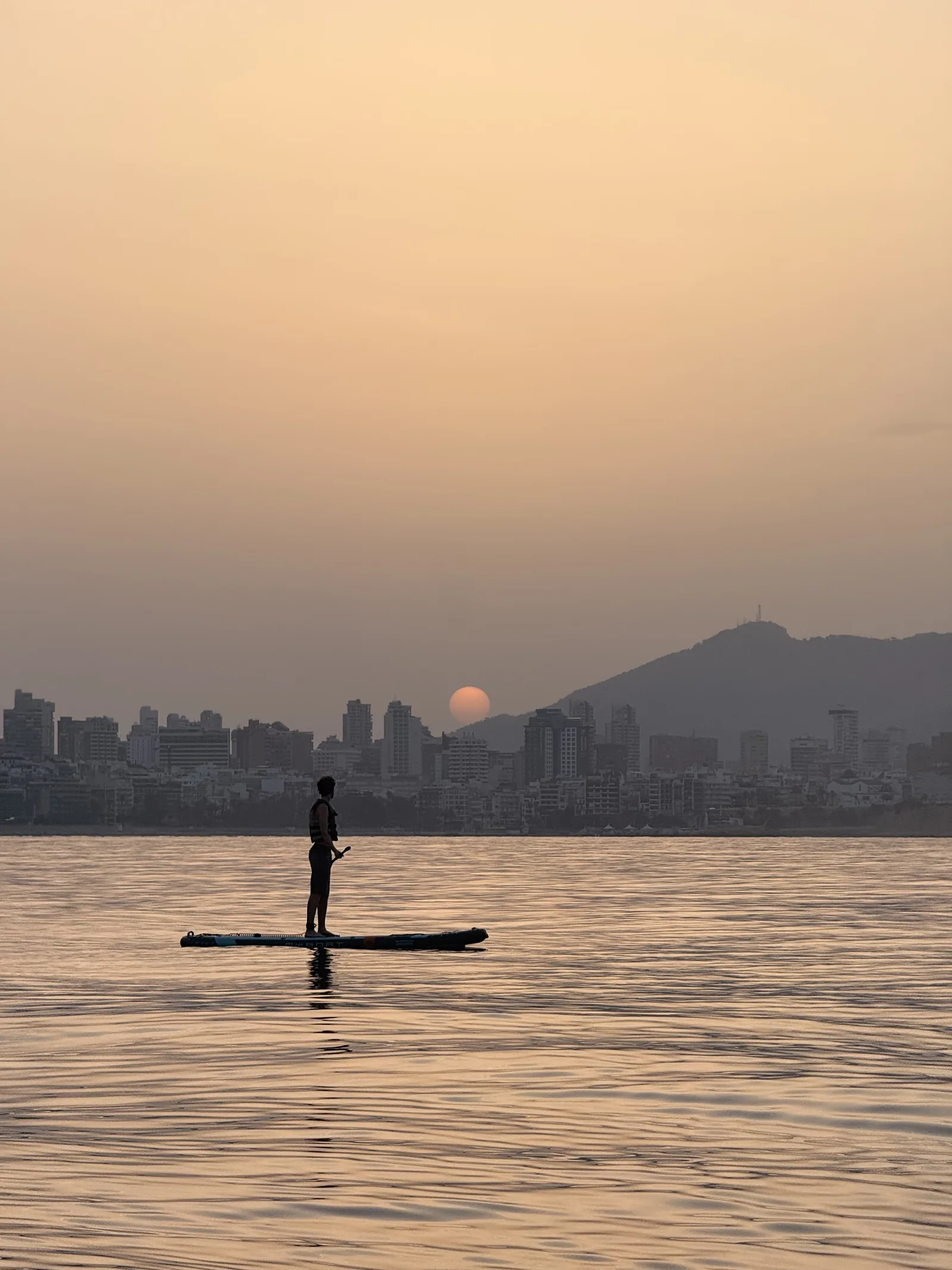 SUP al amanecer con el sol saliendo sobre Benidorm, Costa Blanca
