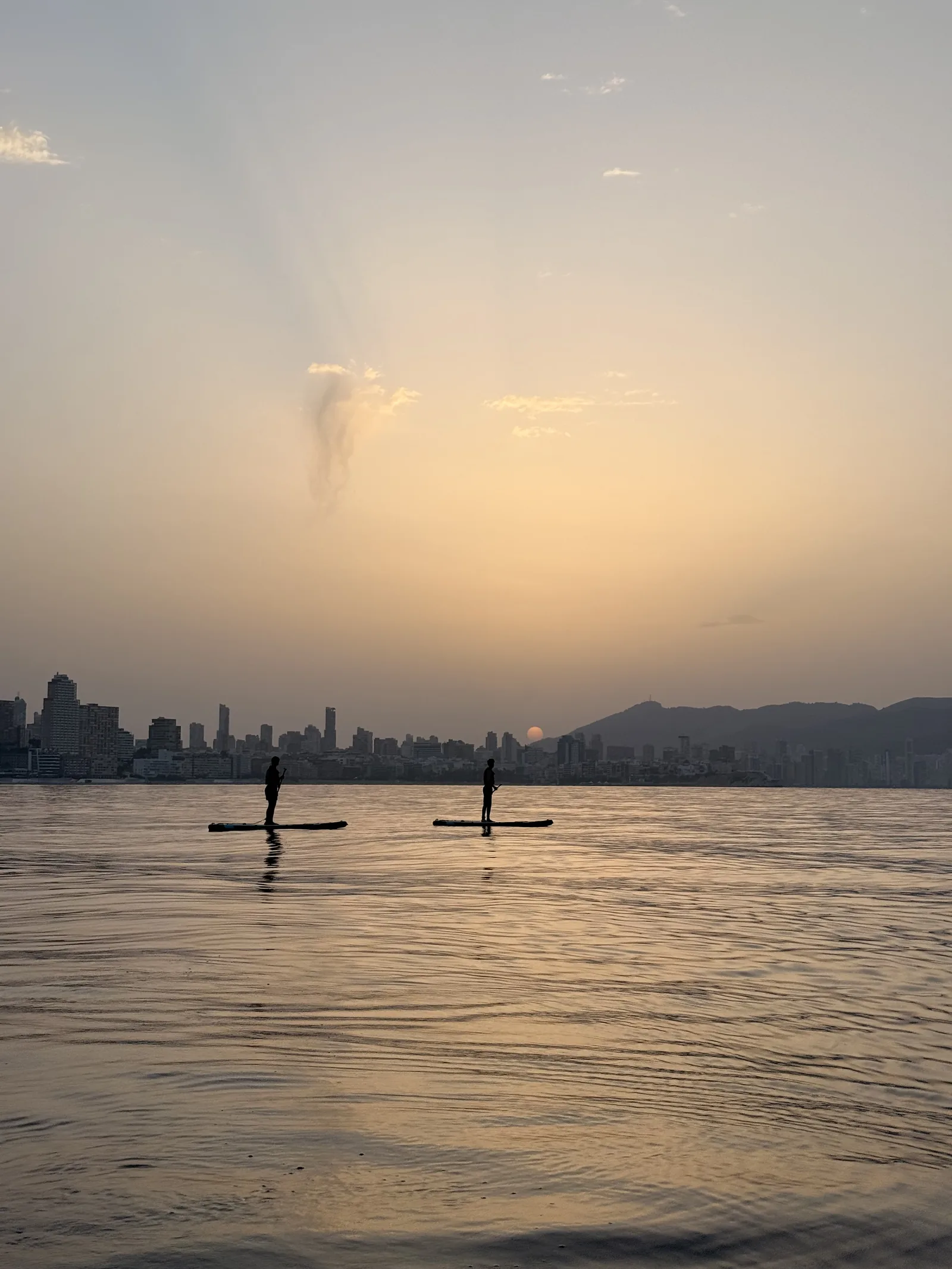 Amanecer remando en paddle surf sobre aguas tranquilas en Benidorm